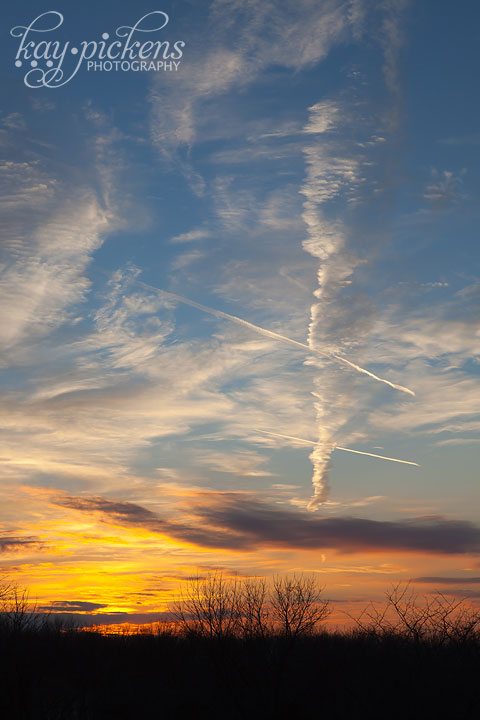 brilliant sunset with pointing contrail clouds
